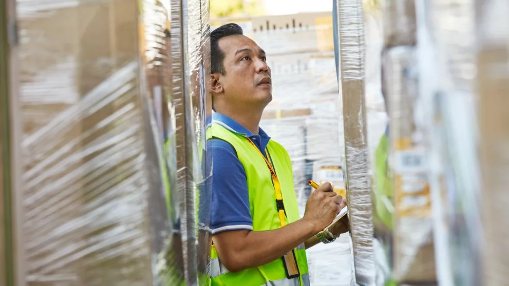 Customs broker reviews import documents at a cargo terminal in Brazil with containers in the background