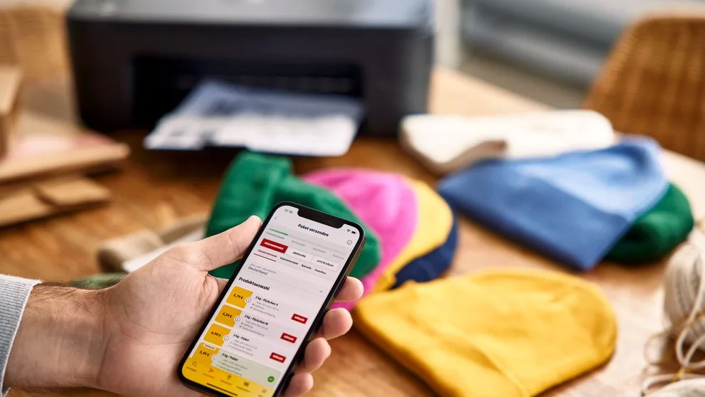 Vendedor organizando pelo celular os pedidos do e-commerce antes da expedição