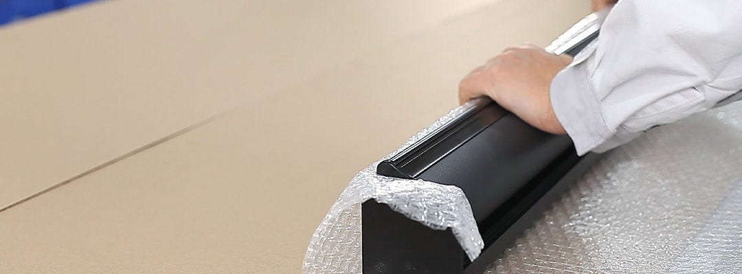 hand wrapping blind frame in bubble wrap