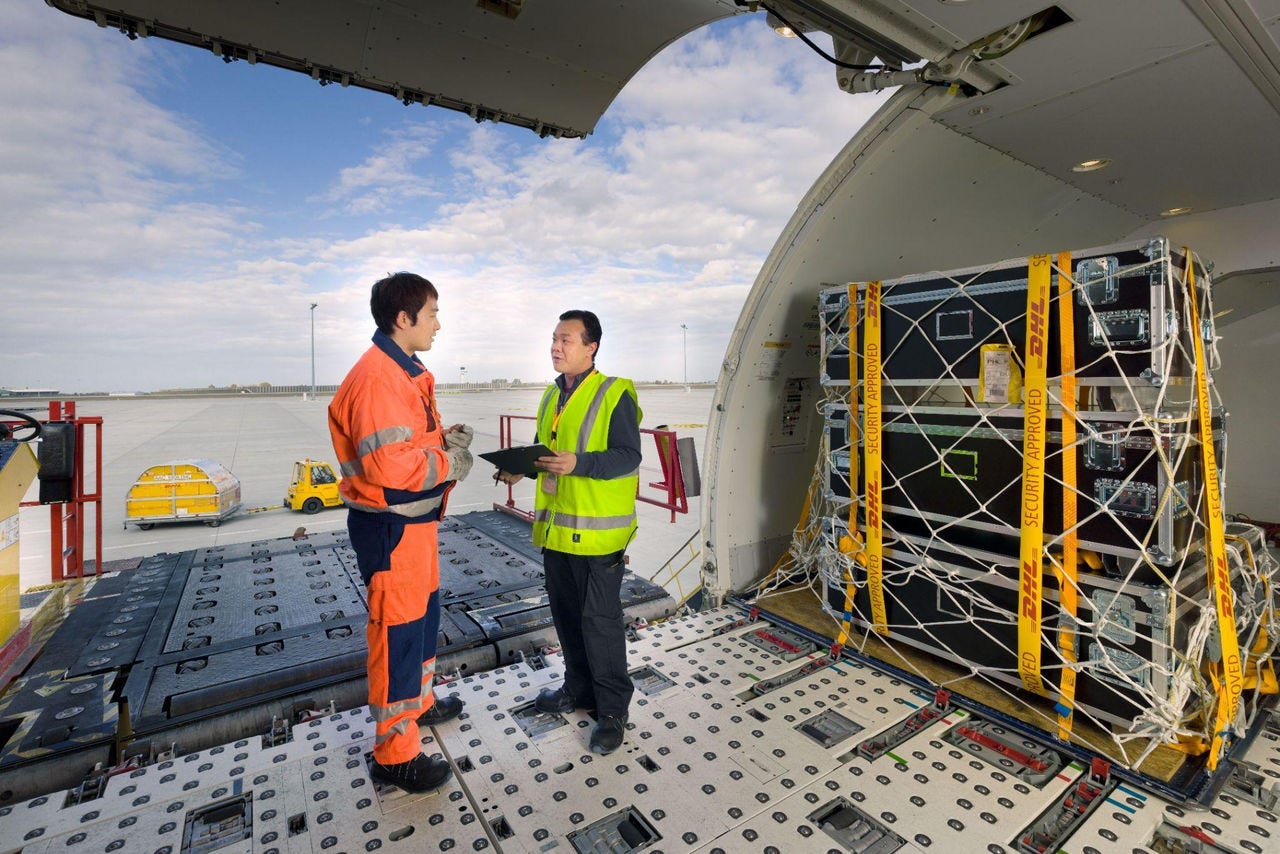 dhl employees securing cargo for air shipment