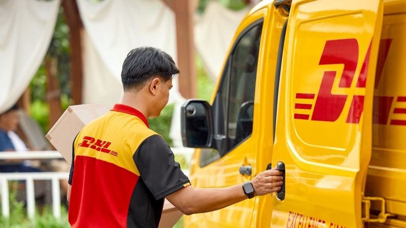 A DHL Express courier in Sri Lanka loads parcels into a yellow DHL  van