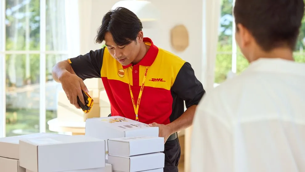Karyawan DHL sedang memindai paket untuk diambil di toko
