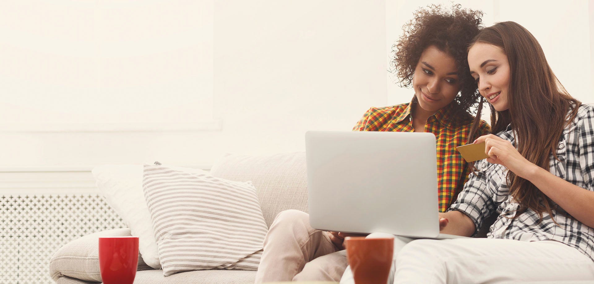 two women smiling and looking at credit card