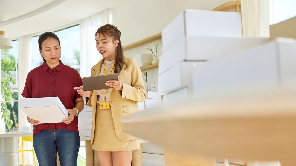 Two employees have a discussion over supplier invoices for B2B commerce in a shop.