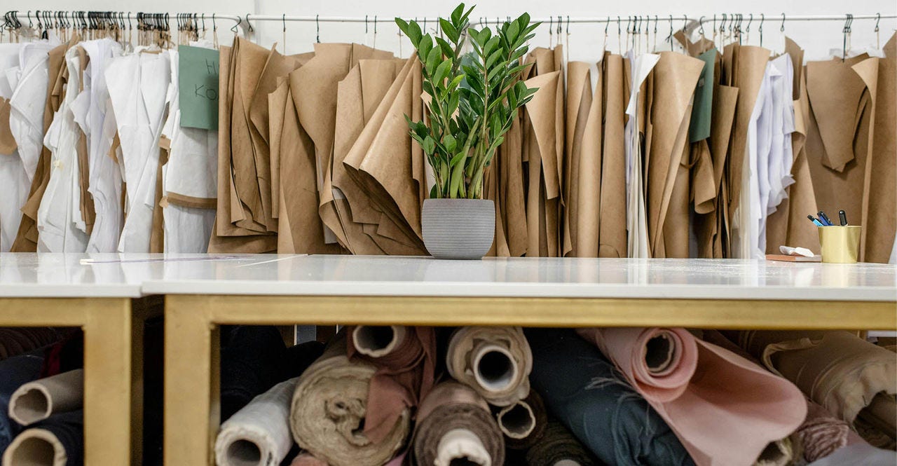 rolls of assorted fabrics and textiles and sewing patterns inside tailor atelier