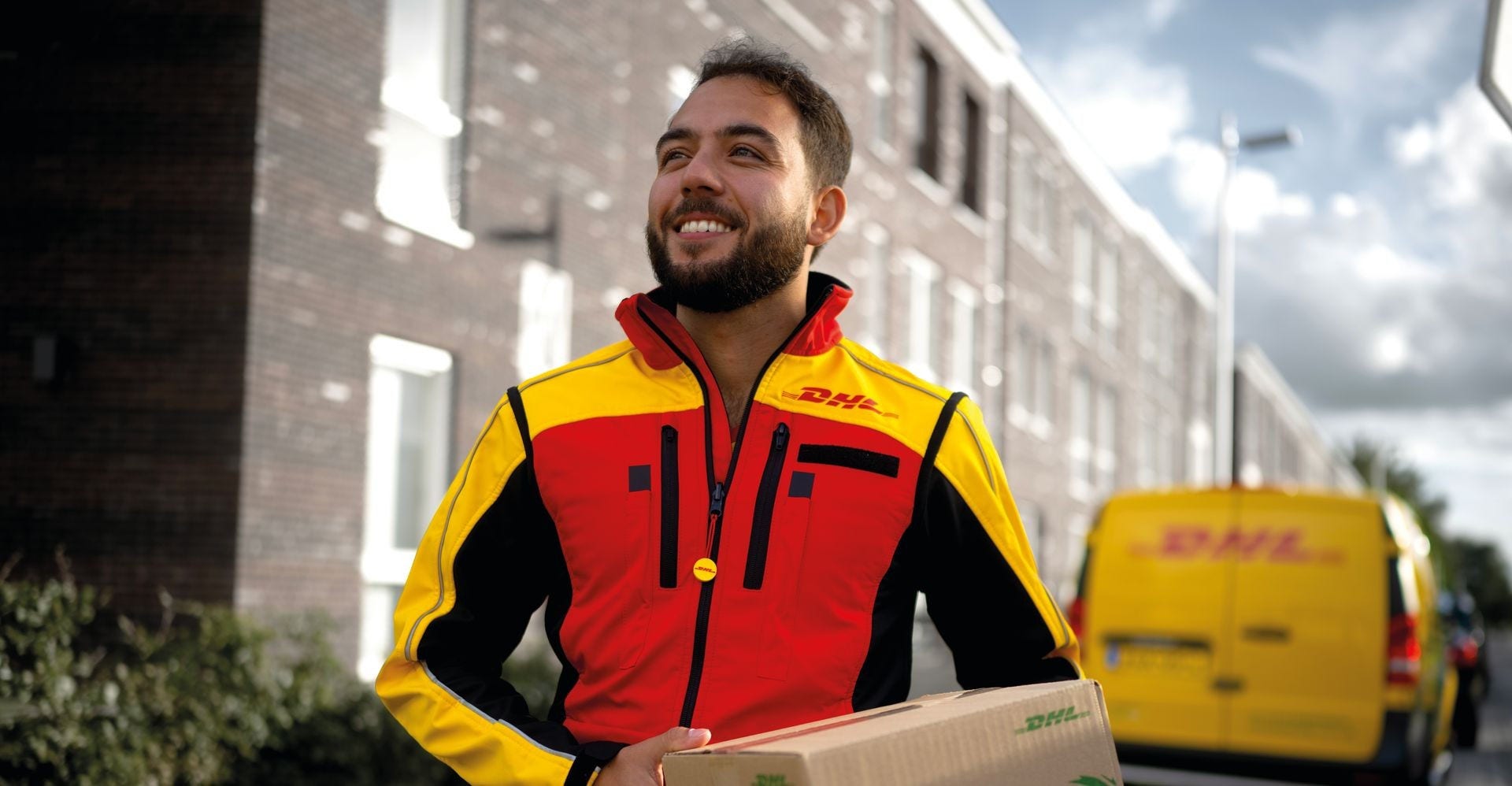 DHL Express employee holding a parcel for delivery