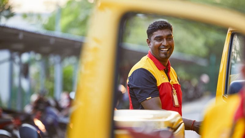DHL delivery personnel framed by his vehicle’s window.