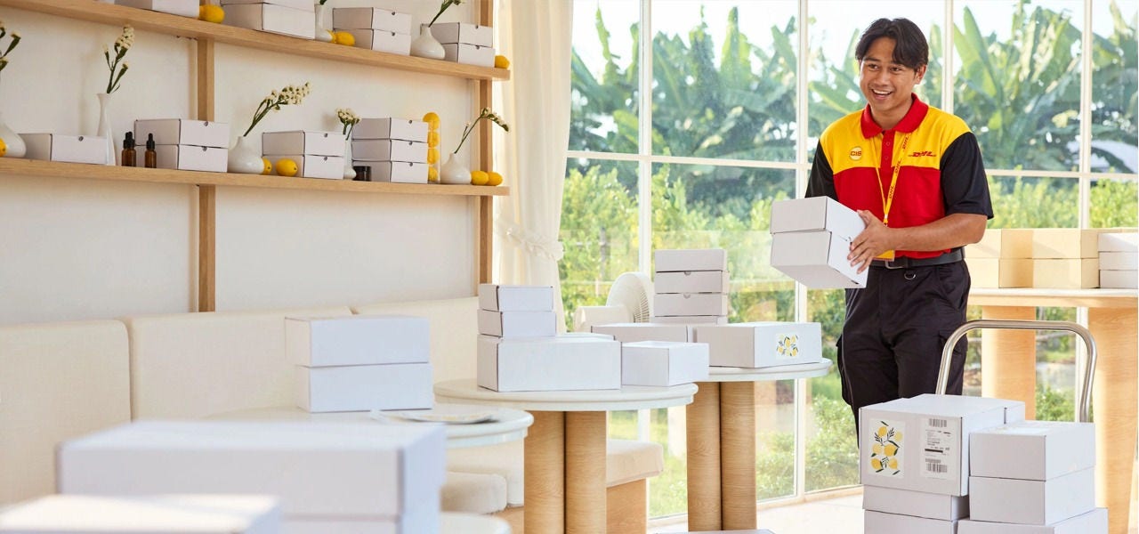 DHL 快递员在初创品牌工作室，交接包装好的货品，准备揽收寄出。
