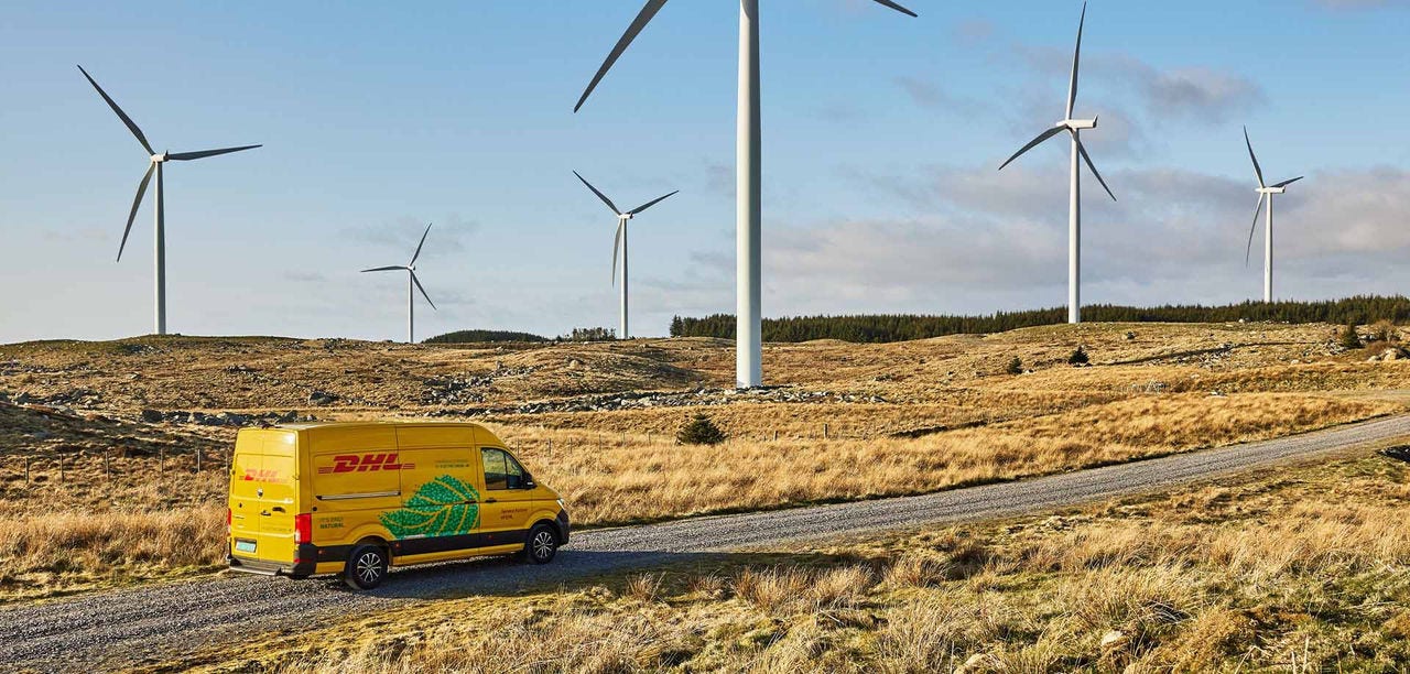 yellow DHL van on a road with windmills