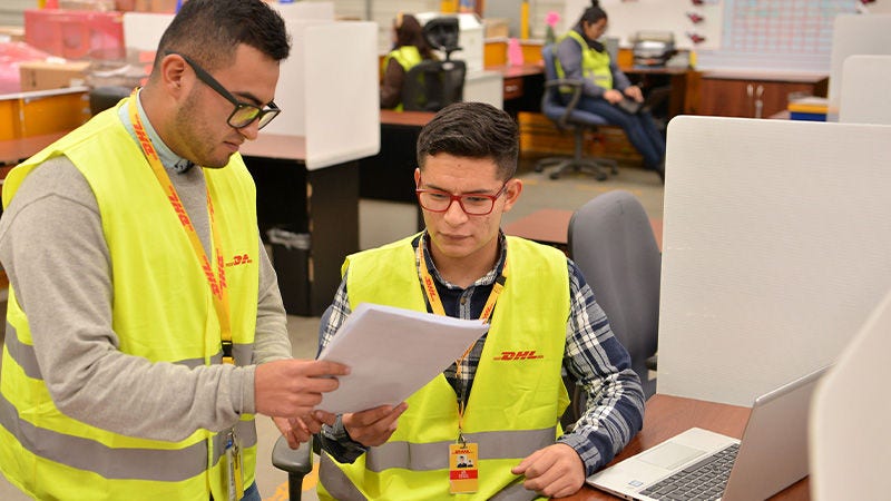 שני עובדי DHL מסתכלים על דף נייר