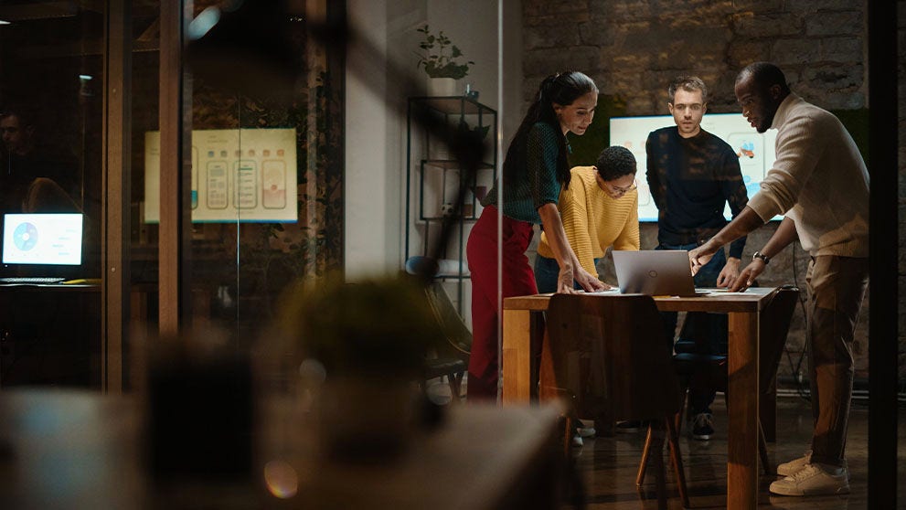 people grouped around a laptop