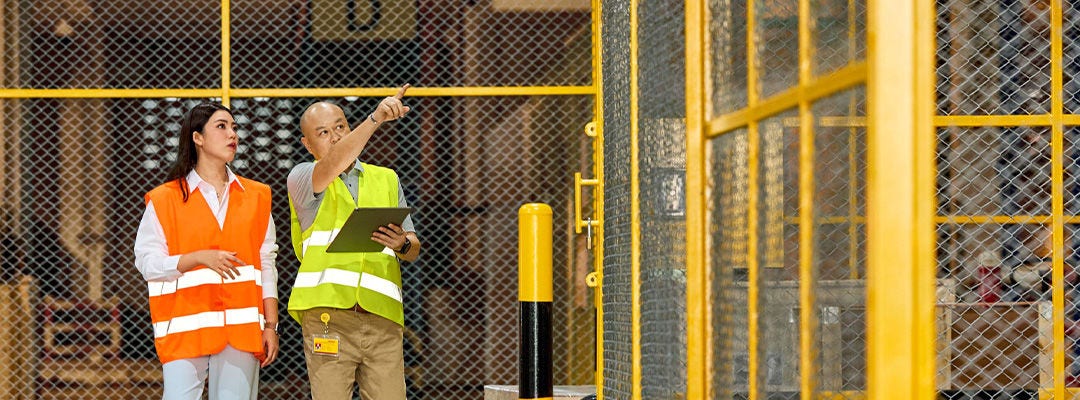 Man and woman in hi vis in a warehouse