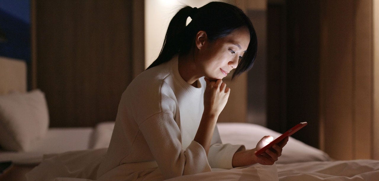 woman smiling at mobile phone