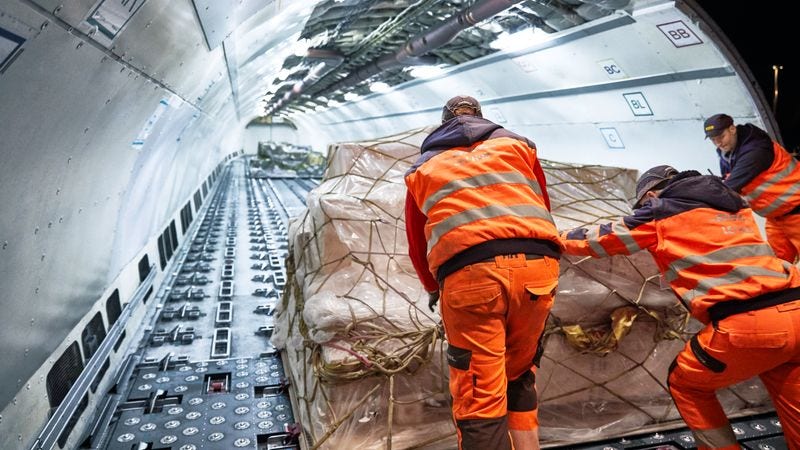 dhl workers loading airplane at night