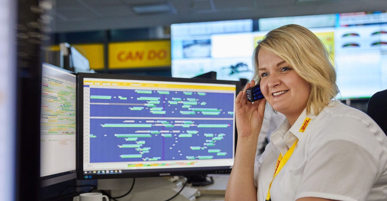 DHL employee sits at her desk and talks on the phone