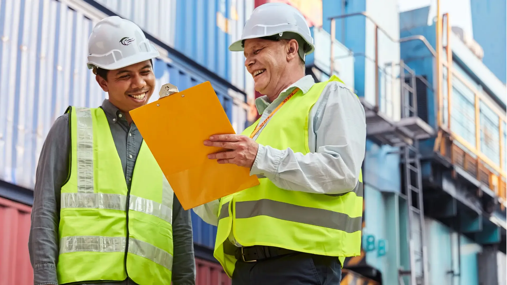 two men in hard hats looking at a clipboard