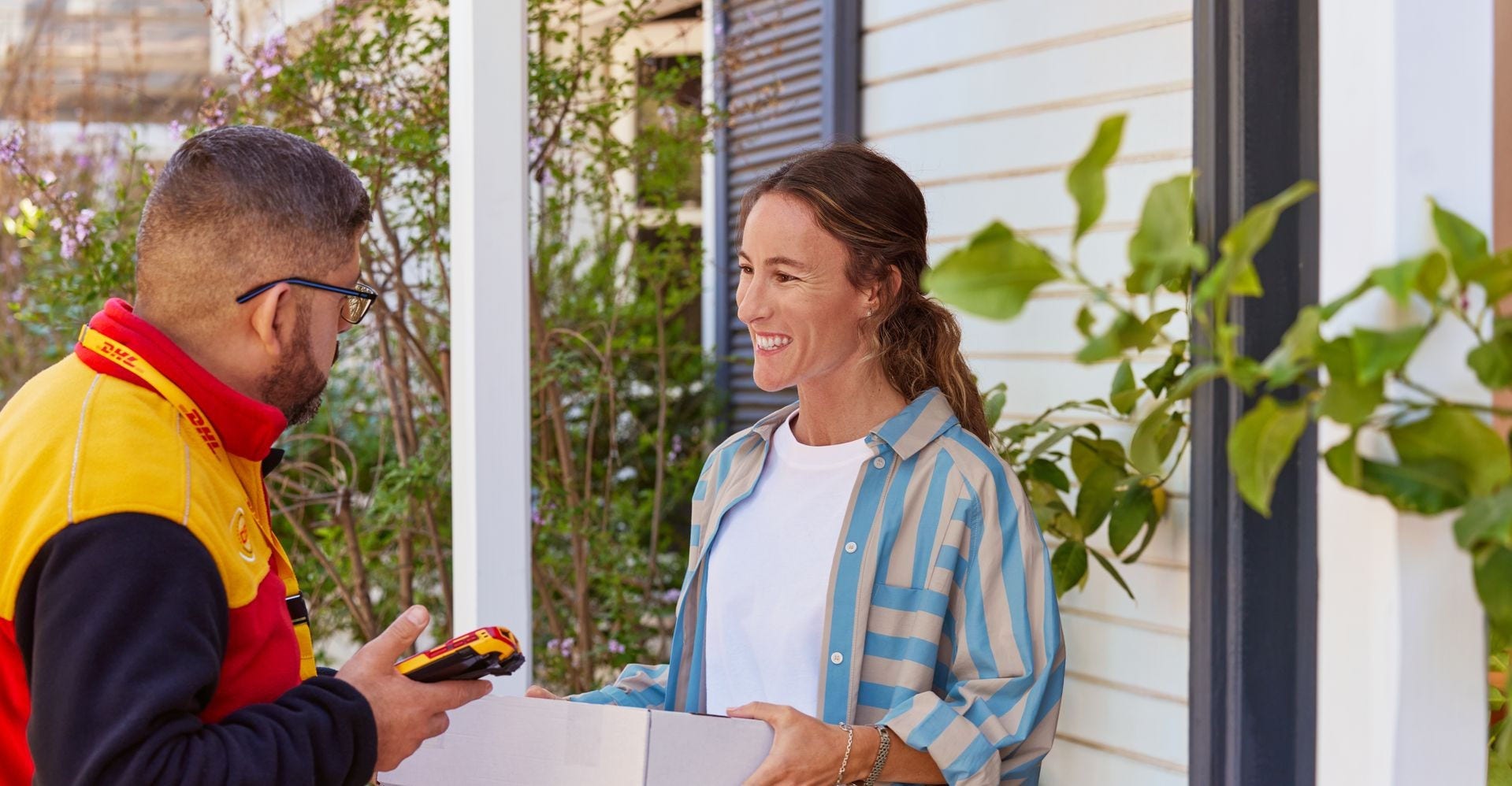 woman hands parcel to DHL courier