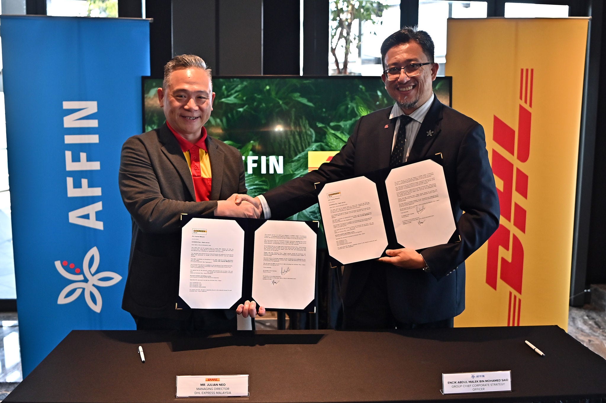 Julian Neo, Managing Director of DHL Express Malaysia and Abdul Malek Bin Mohamed Said, Group Chief Corporate Strategy Chief Officer of Affin Group holding the GoGreen Plus agreements