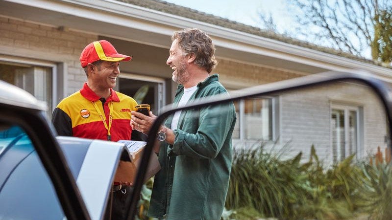 dhl express courier laughing with a business owner