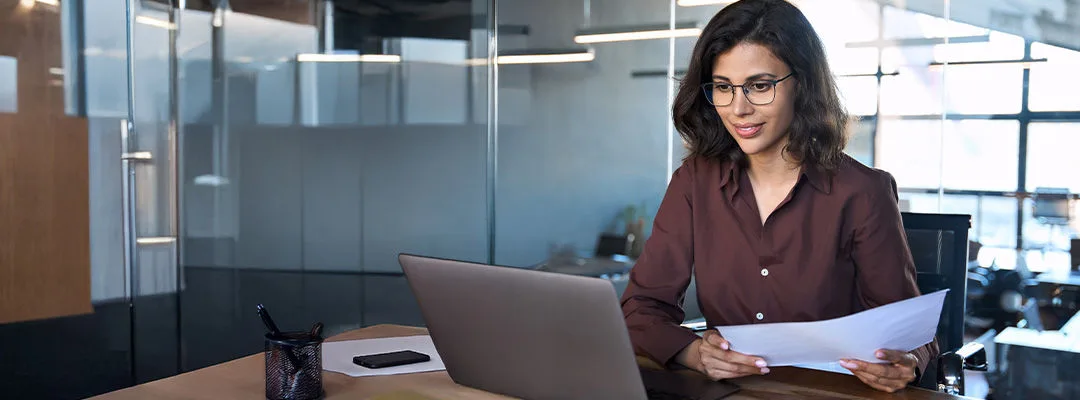 woman in glasses looking at laptop screen