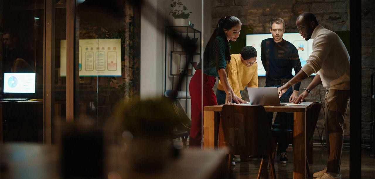 people grouped around a laptop