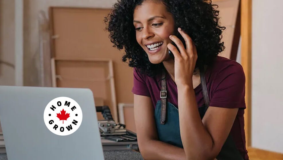 Woman talking on the phone while looking at her laptop