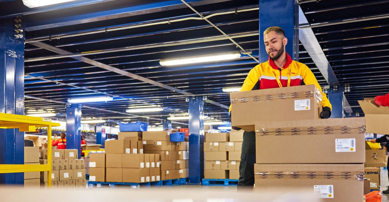dhl employee sorting through parcels