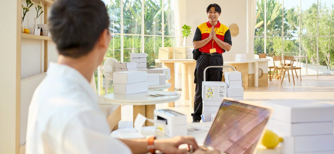 Man passing his packages off to a DHL courier for shipping to the US