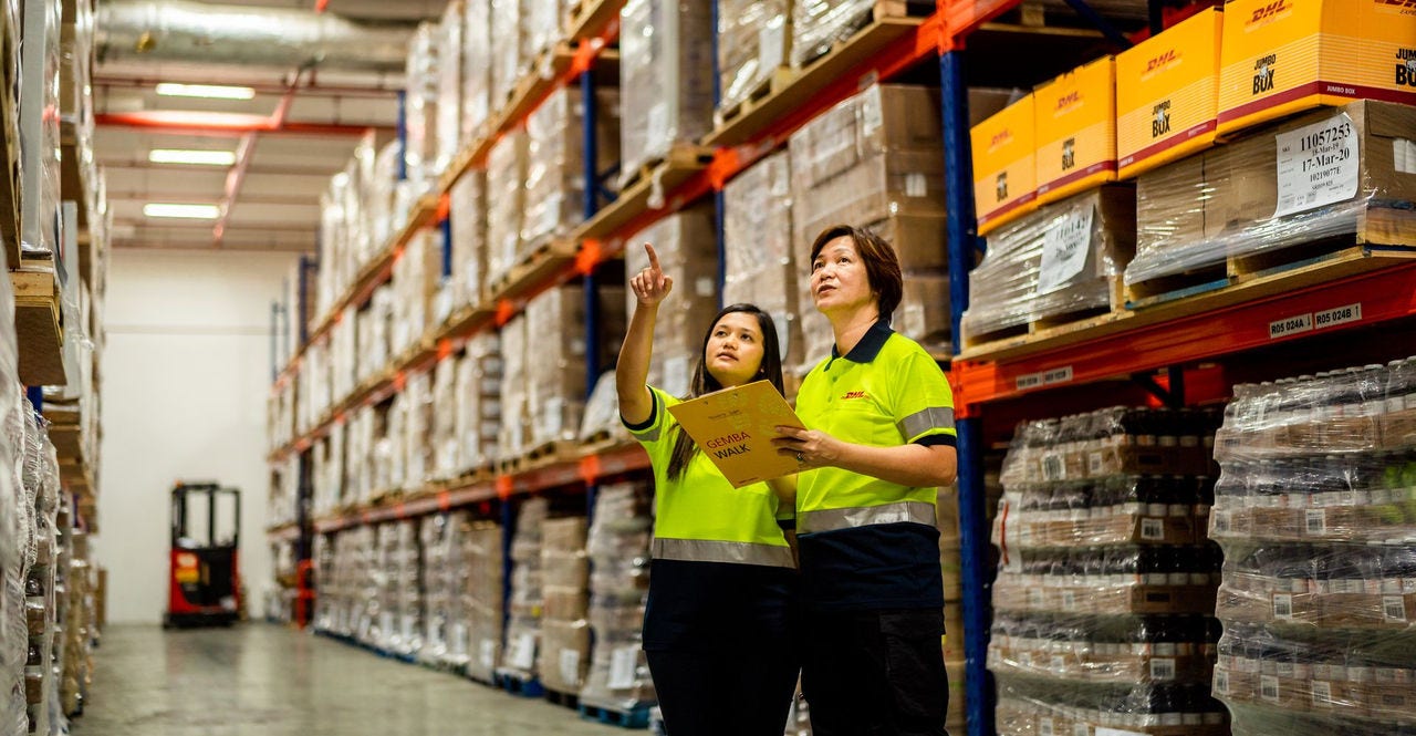 two dhl employees having a discussion in an export hub