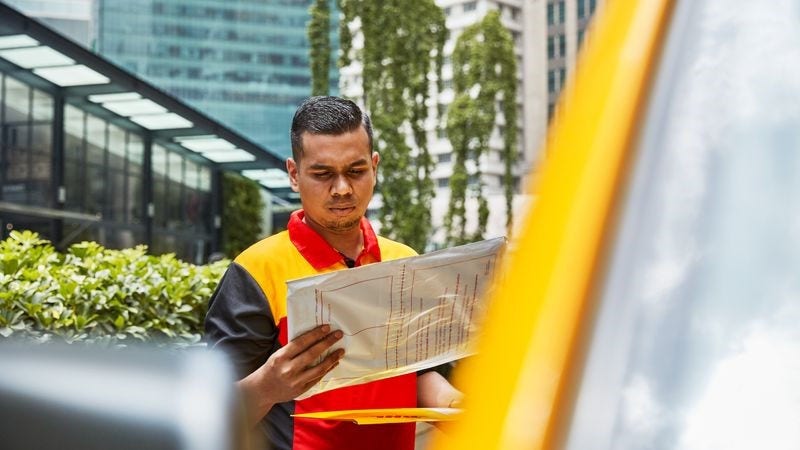 A DHL logistics personnel delivering parcels