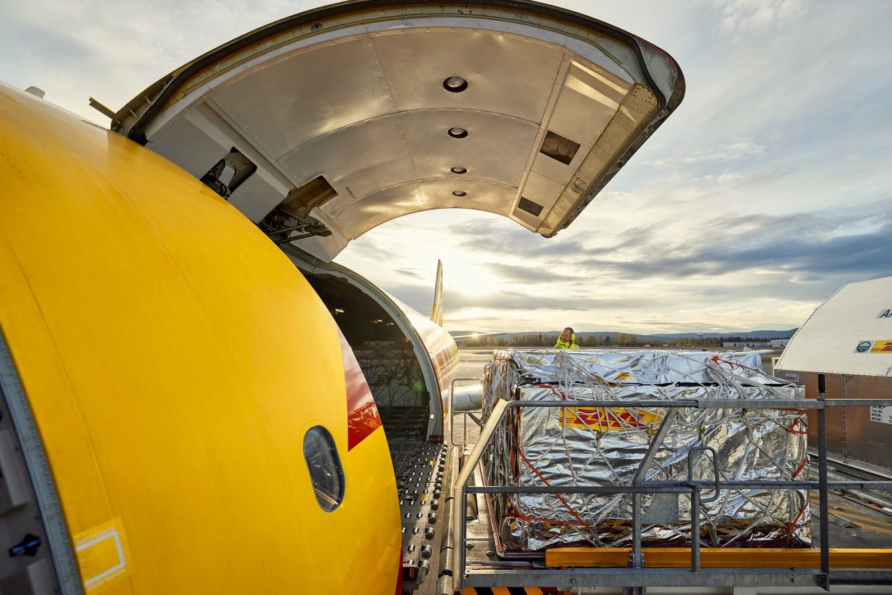 A DHL cargo plane being loaded with packages
