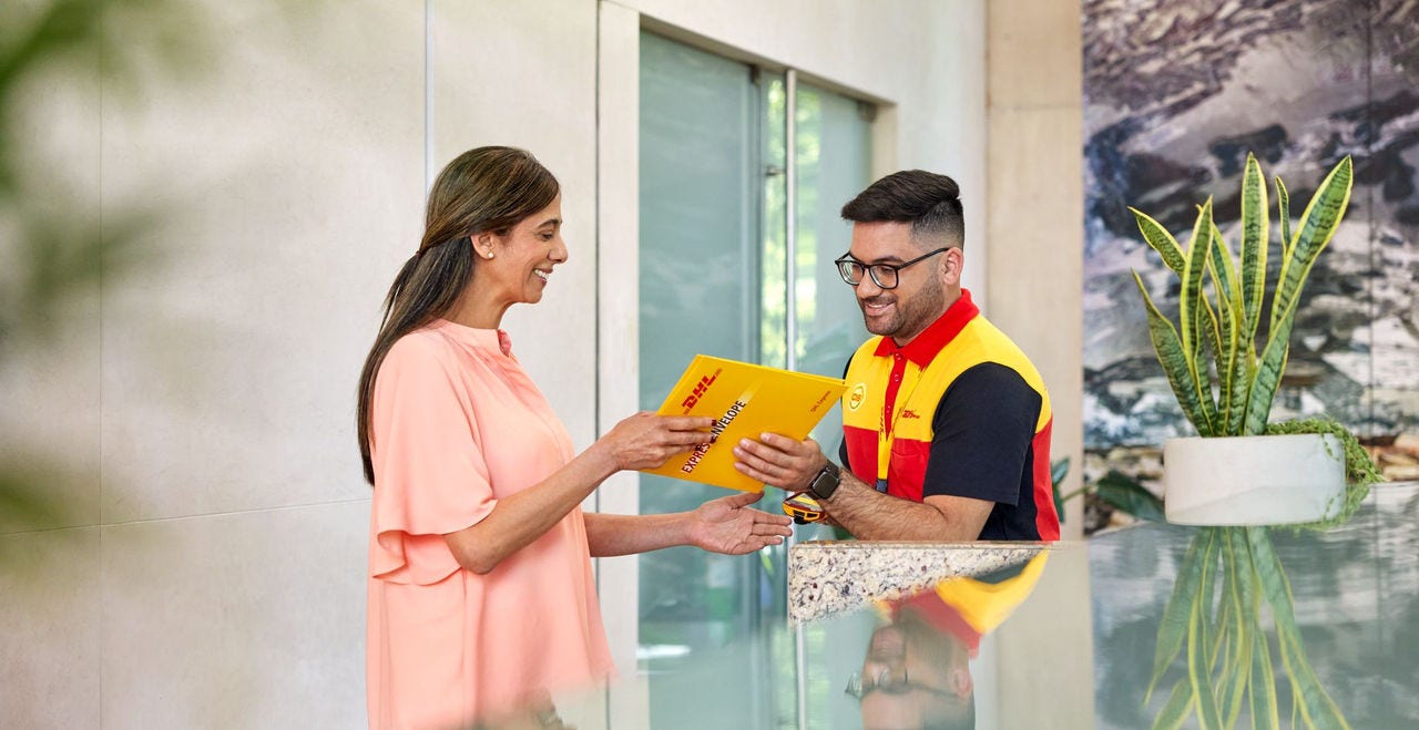male dhl express employee handing over a delivery to a woman