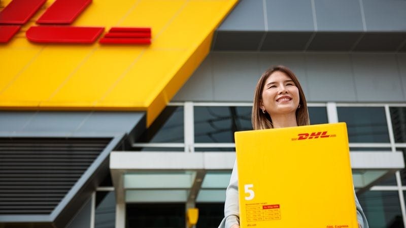A female customer carries her DHL Express parcel.