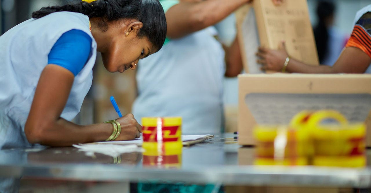 dhl employee checking the ad codes of shipments