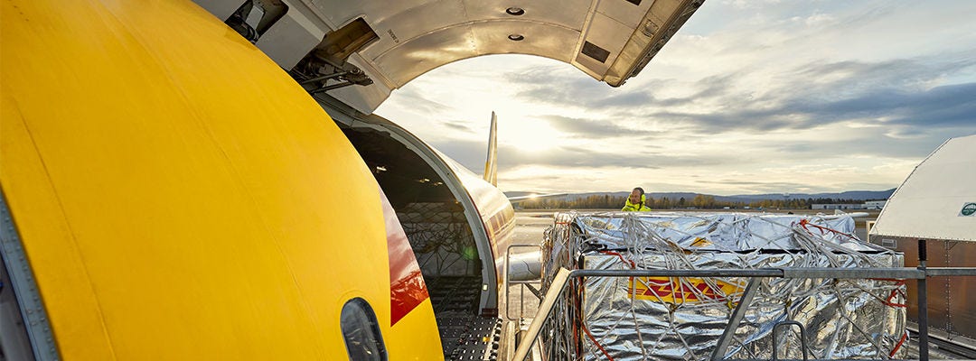 de grandes marchandises palettisées de marque DHL chargées dans un avion de marque DHL