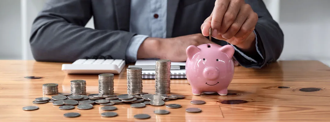 hand putting coin in piggy
