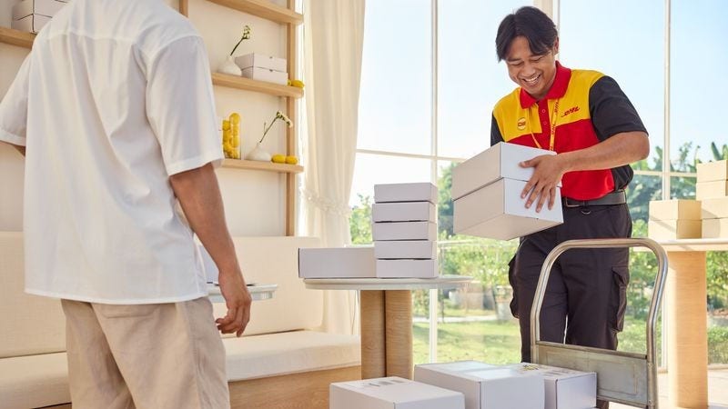 dhl express employee helping customer to prepare parcels for overseas shipping