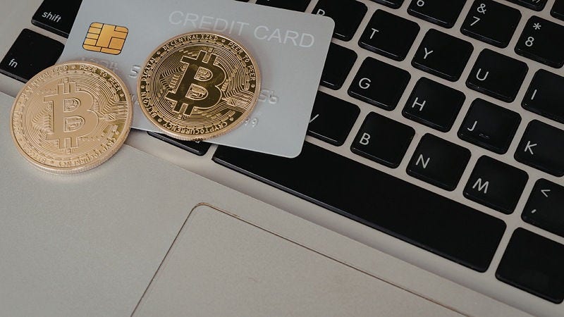Cryptocurrency coin and credit card on a laptop for cross-border payments