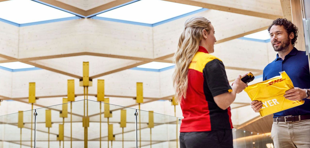 DHL delivery woman handing over a parcel to a man