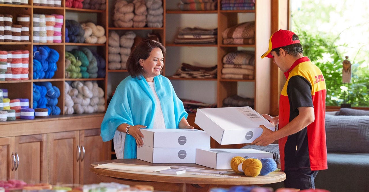 a dhl employee checking the parcels for pickup from a wool shop owner