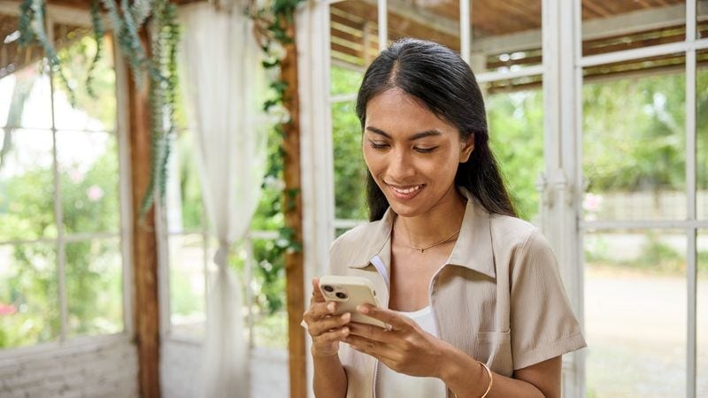 an female ofw tracking the status of her balikbayan box on her phone