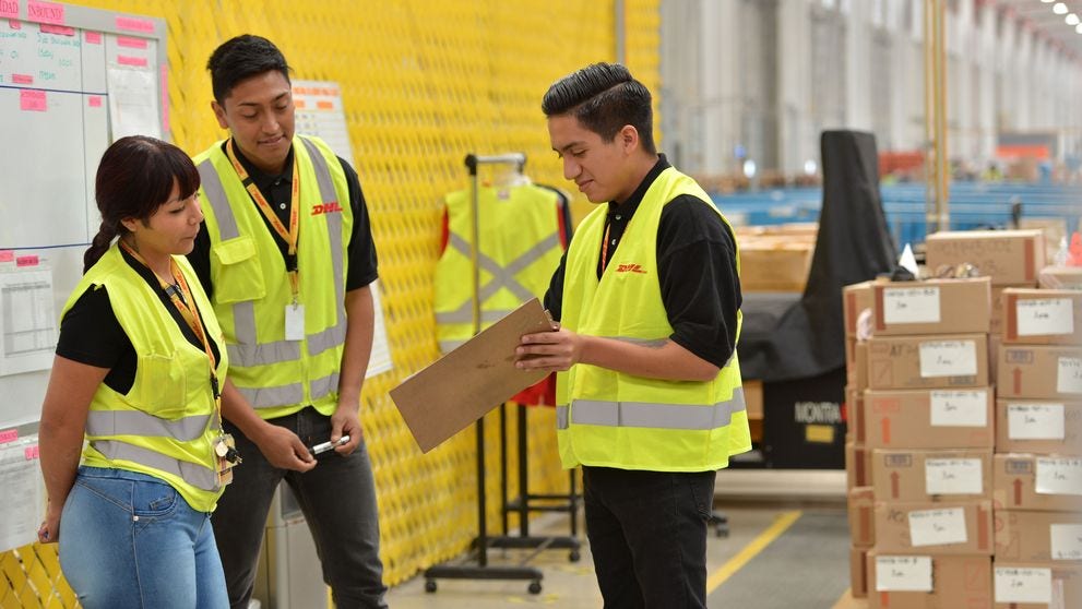 DHL team checking a cargo's paperwork in a warehouse, the step before an import is released