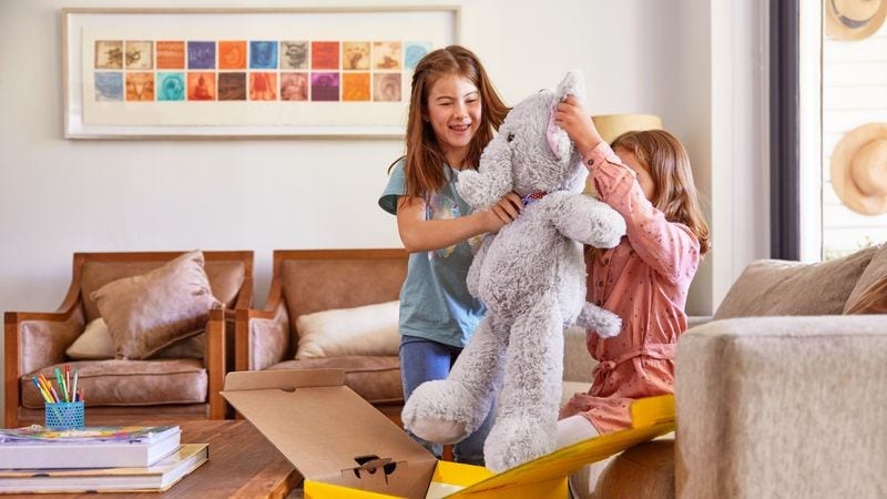 two children opening a dhl express parcel containing a plush toy