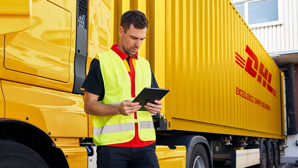 رجل يقف أمام شاحنة DHL