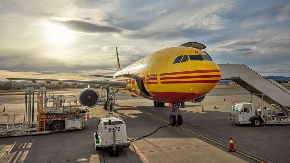a DHL airplane waits at the runway