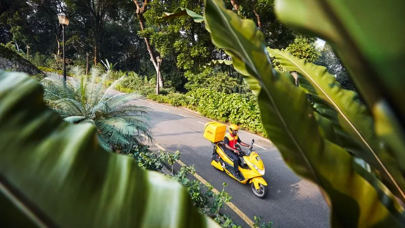 dhl courier driving in an ev motorcycle