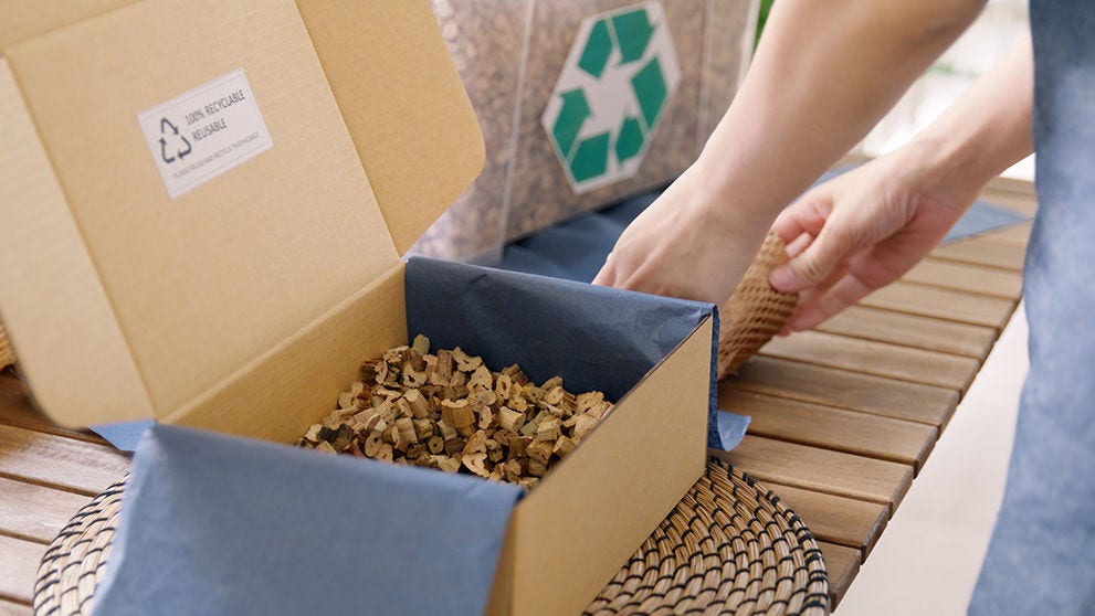 person packaging items in sustainable box