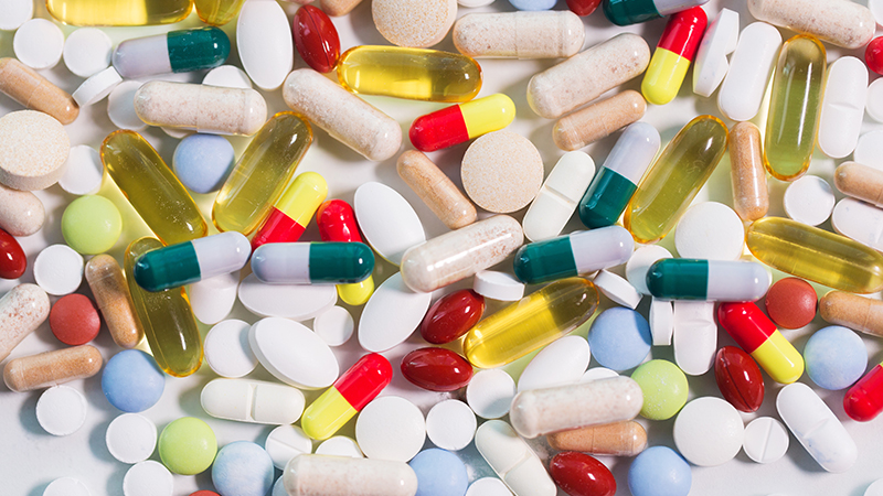 medicine, healthcare and pharmacy concept - different pills and capsules of drugs