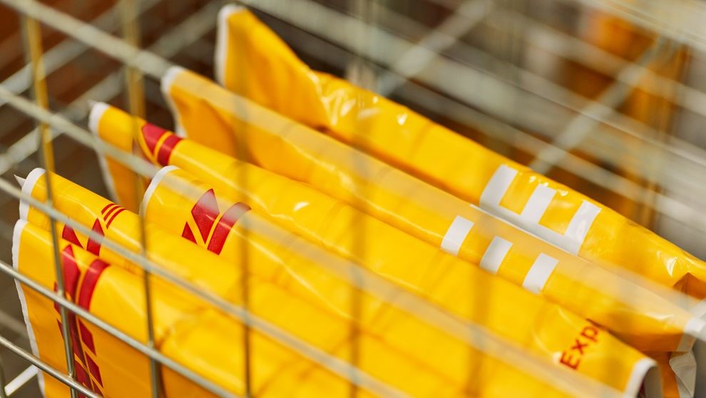 Six DHL packages in a grid bracket for international bulk shipping.