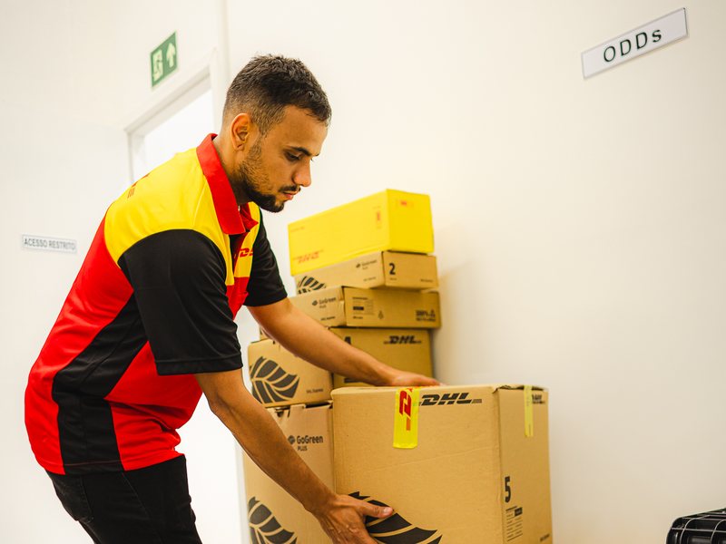 DHL Store agent stacking boxes of a heavy shipment